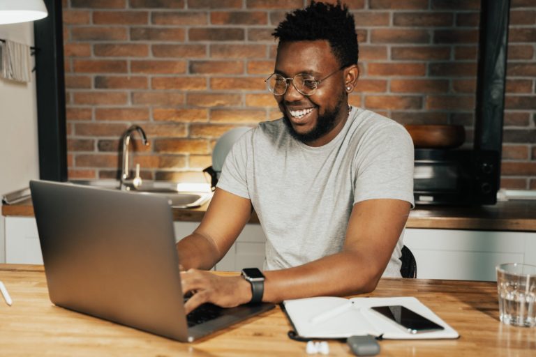 a man sitting at a table with a laptop