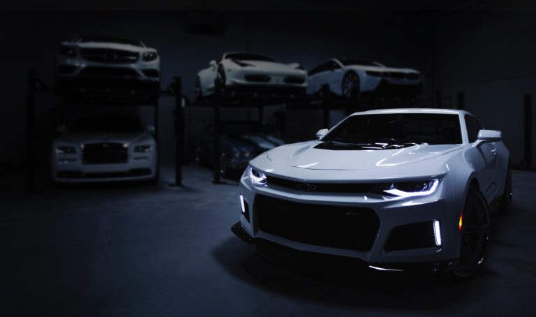 a white sports car parked in a garage