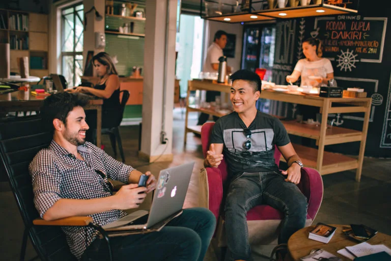 a group of people sitting in a room with a laptop