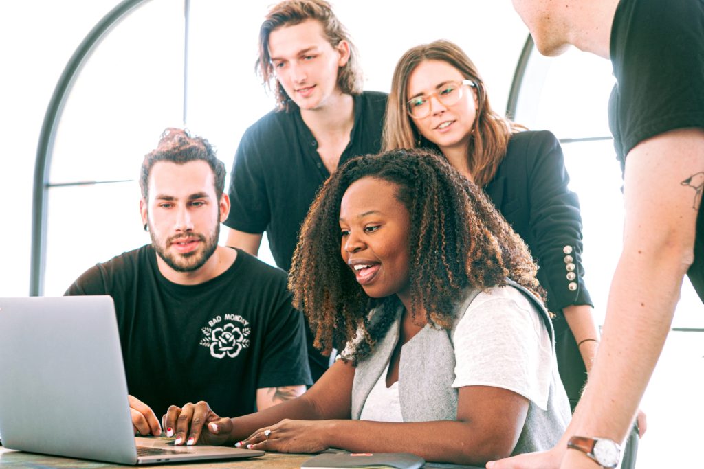 a group of people looking at a laptop