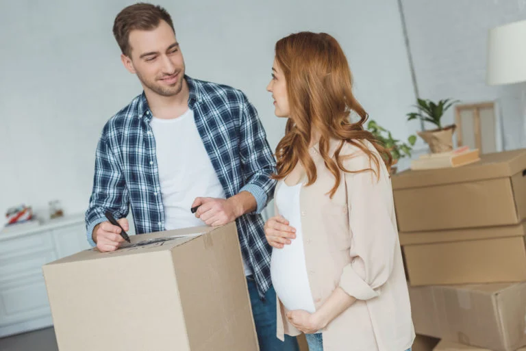 pregnant woman and husband at new apartment, relocation concept